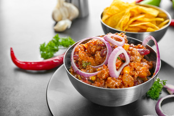 Bowl with chili con carne on table