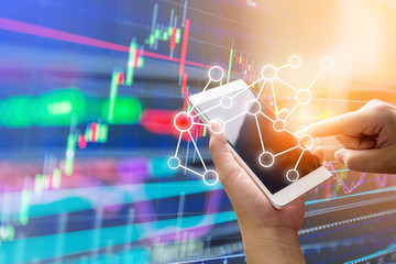 business connection concept with hand use smartphone with background of stock market chart analysis