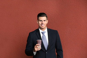 Man in formal suit near red wall