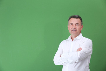 Mature man in white shirt on color background