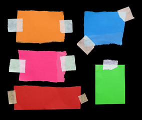 pieces of torn note paper on black. copy space