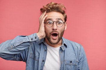 Shocked bearded man with jaw dopped out and bugged eyes, stares at camera as sees awful car...