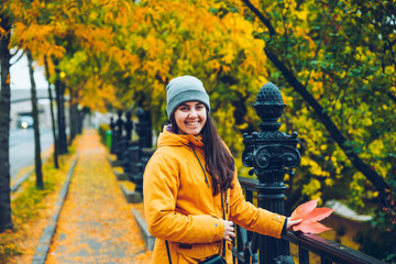 Woman walking on a street full of yellow leaves during Autumn