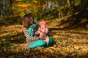 Happy family: mother and child little daughter in nature outdoors