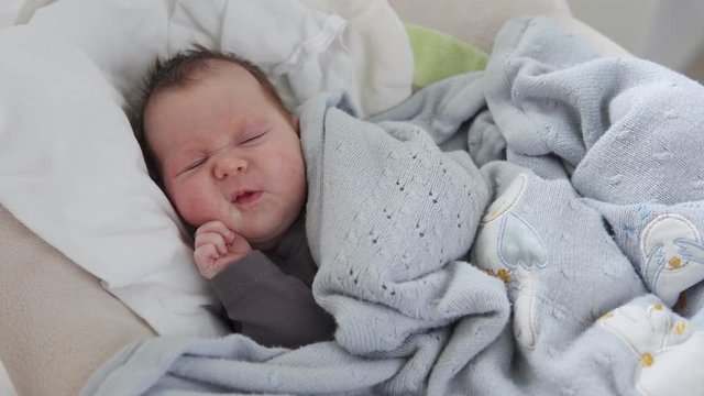 Cute sleepy newborn baby yawning in crib