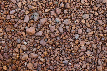Surface of red rocks dirt and pebbles lay on the floor. It was crushed and cracked. Use for background or banner website and template.