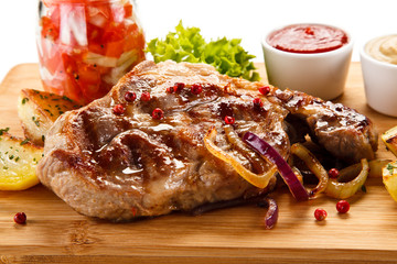 Grilled steak with potatoes on cutting board