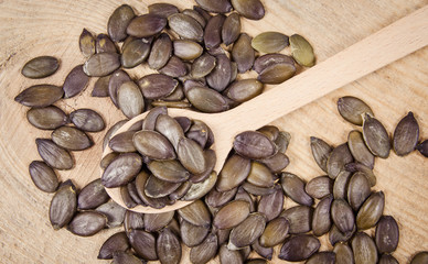 Pumpkin seeds on a wooden background.