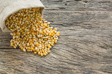 raw corn seeds on old and crack wooden board with copy space for text, top view.