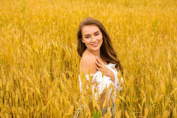 Portrait of a young girl on a background of golden wheat field