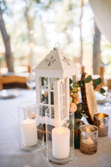 Decorated area with white wooden candle lamps and flowers