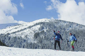Winter Trekking in the mountains. Two men make an ascent to the top.