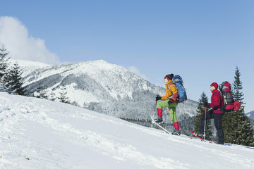 Winter Trekking in the mountains. Two men make an ascent to the top.