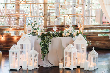 Decorated area with white wooden candle lamps and flowers