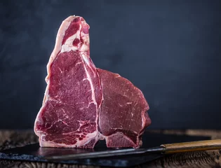 Photo sur Aluminium Steakhouse Bifteck d& 39 aloyau de boeuf. Bifteck de boeuf cru T-bone sur ardoise avec boucher et fourchette