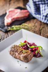 Beef steak with beetroot and herb decoration. Beef steak on plate in hotel or restaurant