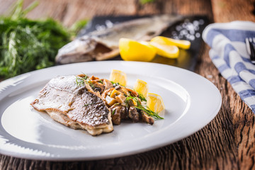 Fish trout with mushrooms and vegetable on plate in hotel or restaurant