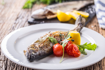 Fish trout with mushrooms and vegetable on plate in hotel or restaurant