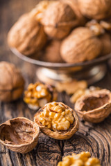 Walnut. Walnut kernels and whole walnuts on rustic old oak table