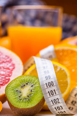 Measure tape and fresh citrus fruit orange lemon tangerine lime lemon and grapefruit.