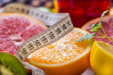 Measure tape and fresh citrus fruit orange lemon tangerine lime lemon and grapefruit.