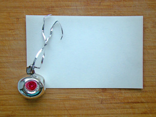 Christmas toy and a piece of paper on a wooden background