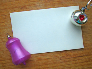 Christmas toys and a piece of paper on a wooden background