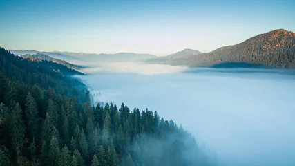 Foto op Canvas An aerial epic landscape, the valley between the mountains is filled with morning fog   © dvv1989