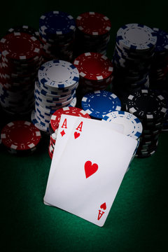 set of aces on a dark poker table