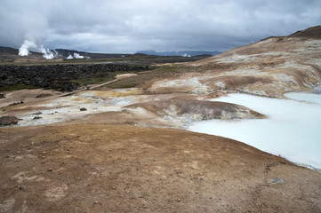 Hverarönd, Iceland. Hot vapors in a typical Icelandic landscape, a wild nature of rocks and shrubs, rivers and lakes.