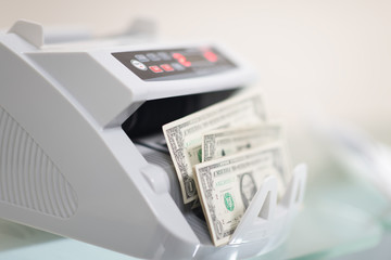 Banknote counter is counting usd (US dollars) banknotes