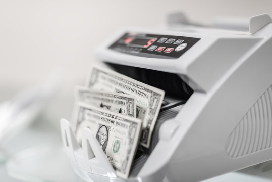 Banknote counter is counting usd (US dollars) banknotes