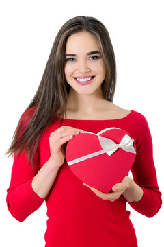 Beautiful happy smiling young woman holding red heart gift box with valentine's present inside, isolated on white background. Valentine's day image.
