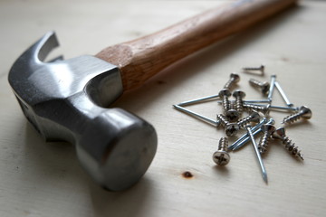 Nails, screws, and a hammer on home improvement construction site