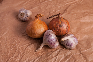 onions and garlic heads on a brown background