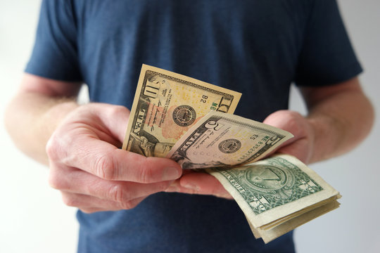 Man counting US dollar bills cash on hand