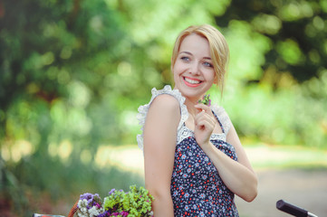 A healthy woman. Beauty Summer model girl with bright flowers happy forest. style leisure. A beautiful white lady. A nice face with a smile and a mystery. place for banner and advertisement