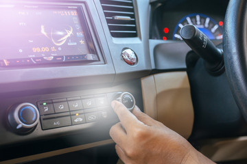 Hand turning on car air conditioning system,Button on dashboard in car panel