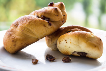 Soft fresh buns with raisins on a plate