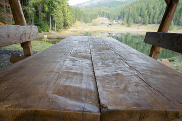 Wooden picnic table beside a lake in autumn
