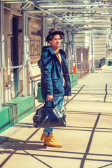 American guy traveling, walking on sidewalk bridge in New York, wearing blue jacket with hood,...