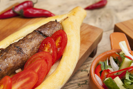 sausage grill with cherry tomatoes on a kitchen wooden table