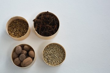 Nutmegs, white pepper, coriander seed and star anise in bowl