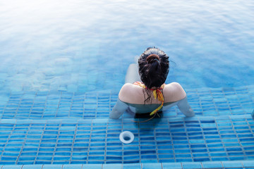 asian Woman in bikini relaxing at the pool summer comcept