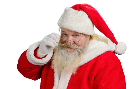 Santa Claus removing his glasses. Portrait of cheerful Santa Claus isolated on white background close up. Santa Clause tuching his eye glasses.
