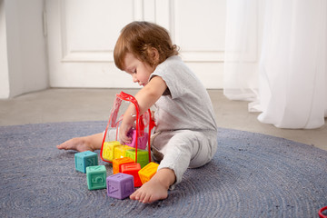 Little happy girl playing with toy on floor. Kindergarten.