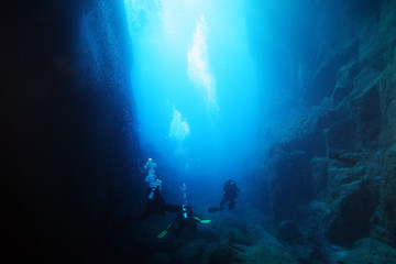 Naklejka na ściany i meble Underwater caves in the ocean with scuba divers