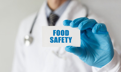 Doctor holding a card with text Food Safety, medical concept