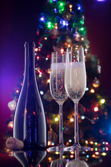 close up view of champagne bottle with flutes  on color back