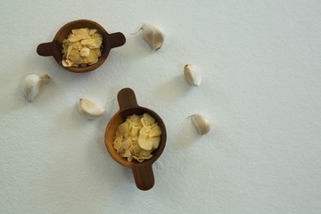 Spices in bowl with garlic on white background